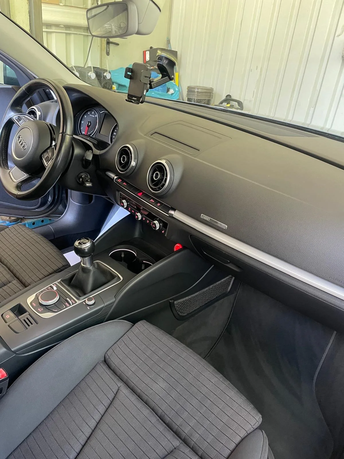 Audi-Cockpit mit runden Lüftungsdüsen, Schaltgetriebe, Stoffsitzen und Beifahrerfußraum