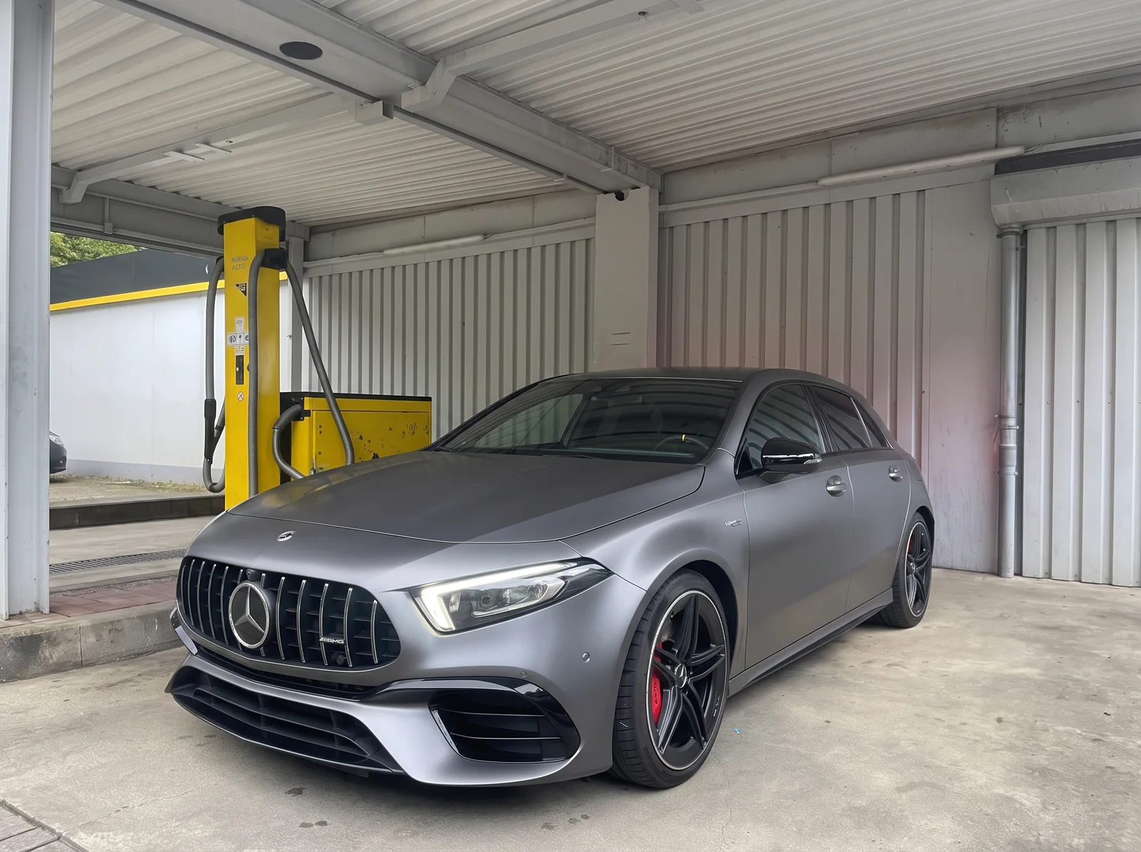 Mattgrauer Mercedes-Benz Kompaktwagen mit schwarzen Felgen und roten Bremssätteln