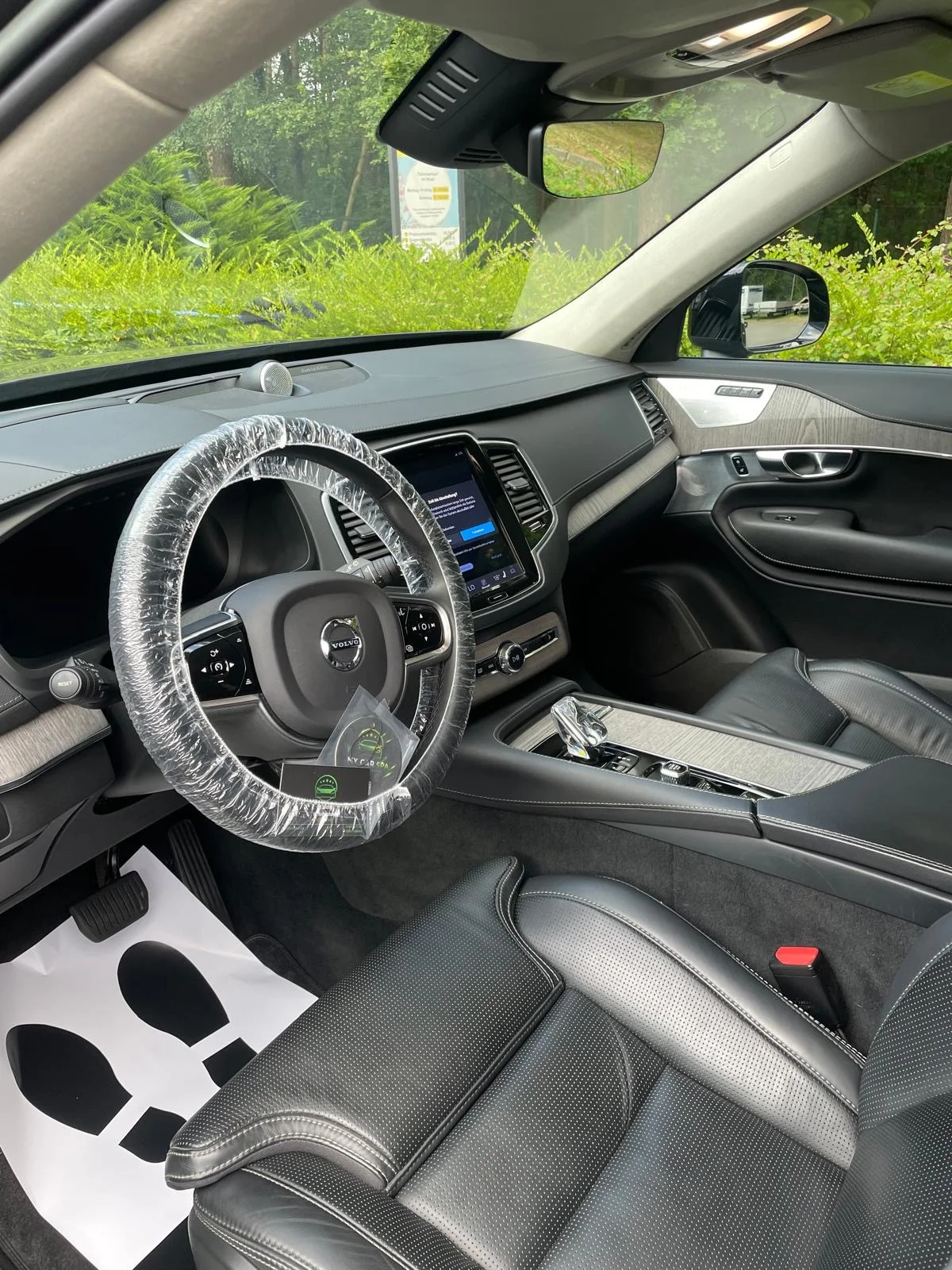 Volvo-Innenraum mit schwarzen Ledersitzen, Holzdekor und Lenkradschutz